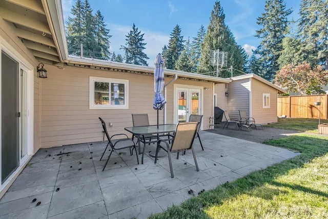 a view of a house with backyard and sitting area