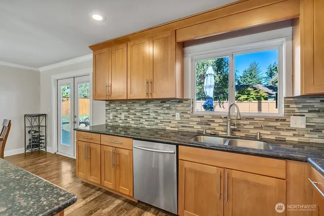 a kitchen with stainless steel appliances granite countertop sink stove and cabinets