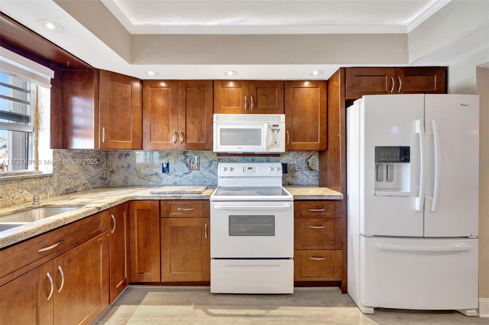 700 Southeast 6th Avenue, Unit 203 Deerfield Beach, FL 33441 - Photo 1 of 43 a kitchen with stainless steel appliances granite countertop white refrigerator stove a sink and dishwasher