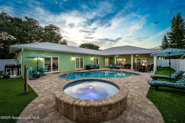 a view of a house with swimming pool and sitting area