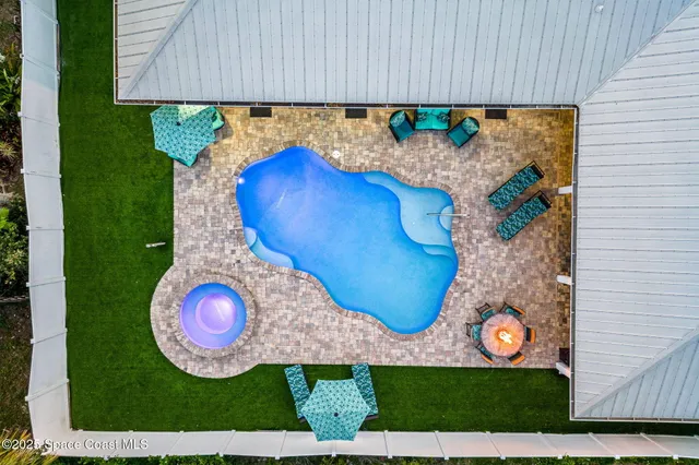 a view of a swimming pool with a lounge chair and a fire pit