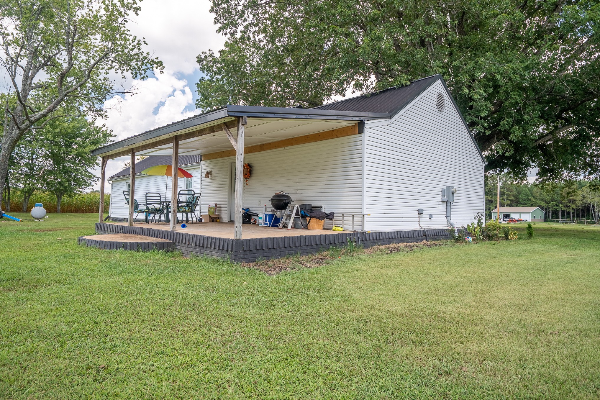 231 Rabbit Trail Road Leoma, TN 38468 - Photo 10 of 37 a view of a patio with table and chairs potted plants and large tree