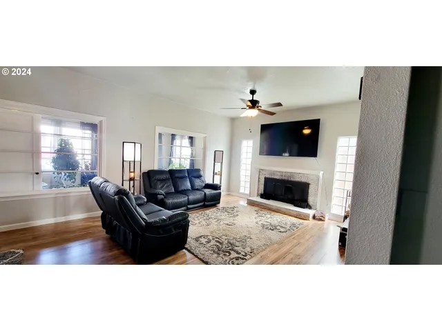 a living room with furniture and a fireplace with wooden floor
