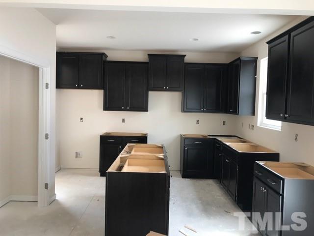 Spacious kitchen with lots of cabinets and center island!  Sink will be under the window!  Espresso cabinets and El Dorado granite (going in soon!).