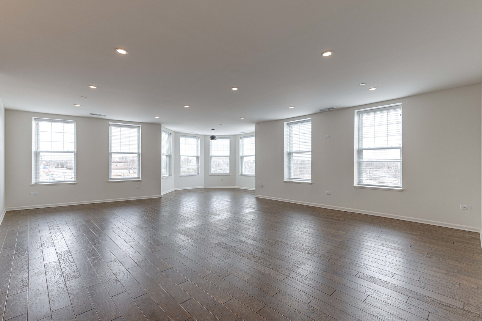 115 Lake Street, Unit 313 Libertyville, IL 60048 - Photo 2 of 10 a view of an empty room with wooden floor and a window