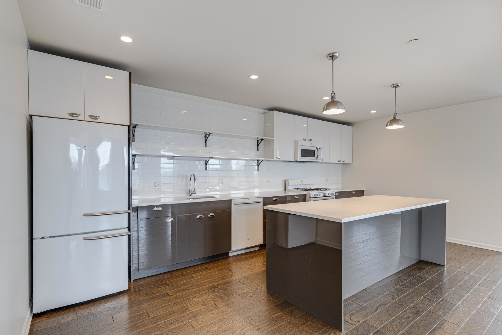115 Lake Street, Unit 313 Libertyville, IL 60048 - Photo 4 of 10 a kitchen with kitchen island a sink a stove a refrigerator and island with wooden floor