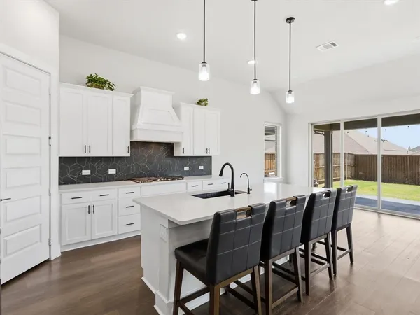 a kitchen with granite countertop a sink a center island and cabinets