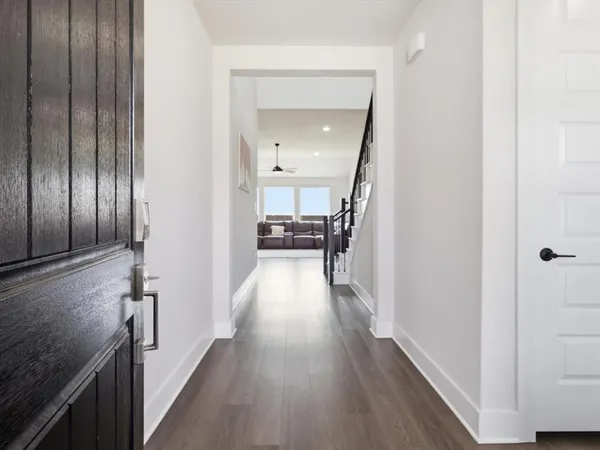 a view of a hallway with wooden floor and staircase