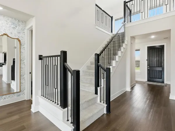 a view of a hallway with wooden floor and entryway