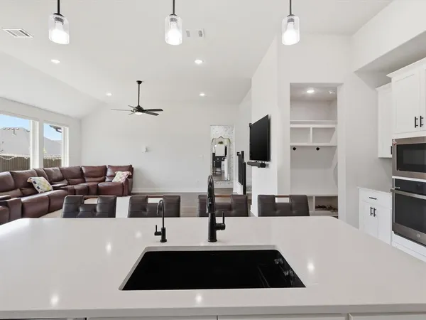 a kitchen with stainless steel appliances a sink a stove a refrigerator and cabinets