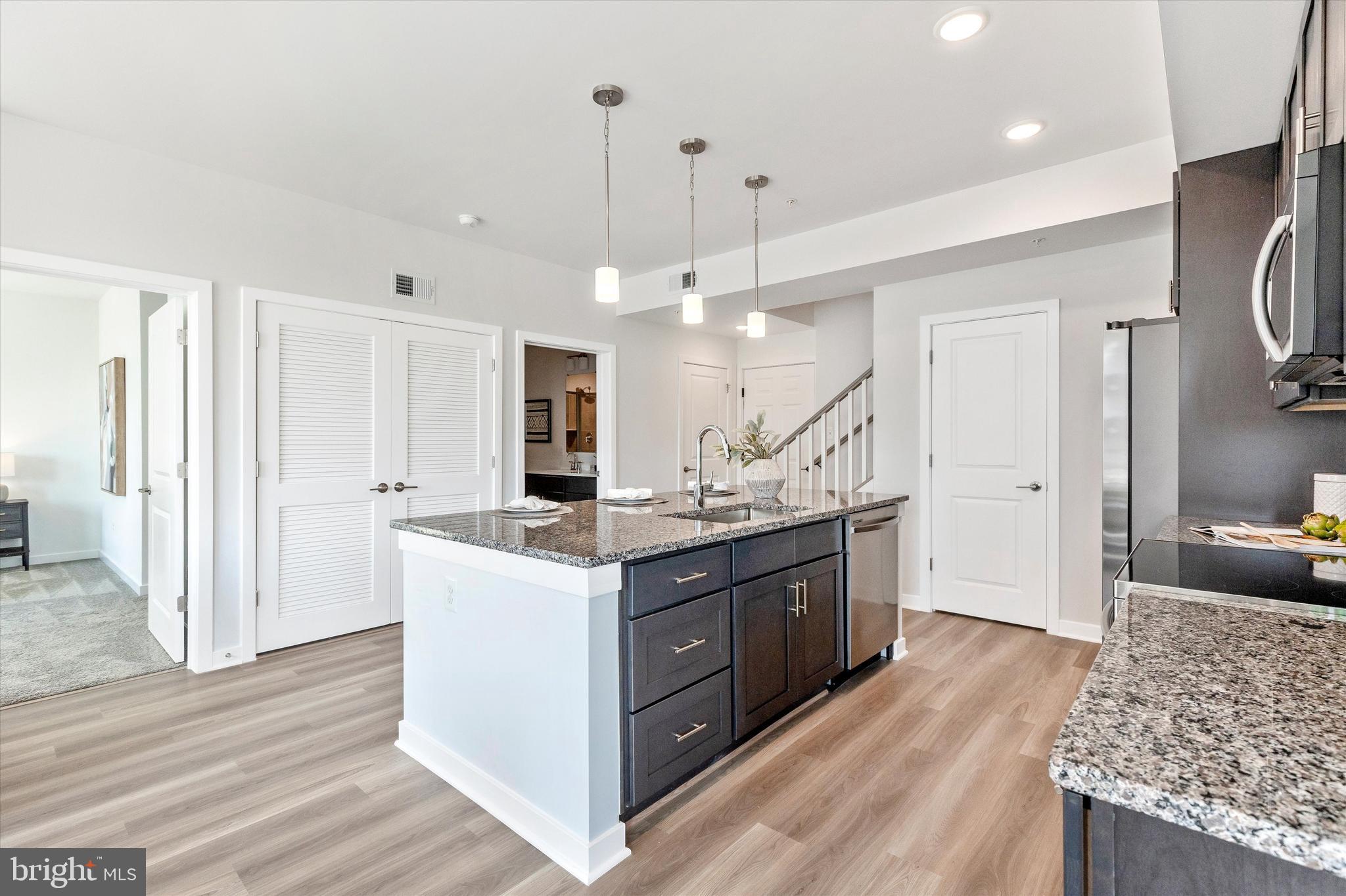 714 Iron Frg Road Frederick, MD 21702 - Photo 12 of 36 a kitchen with stainless steel appliances granite countertop a sink stove and wooden floor