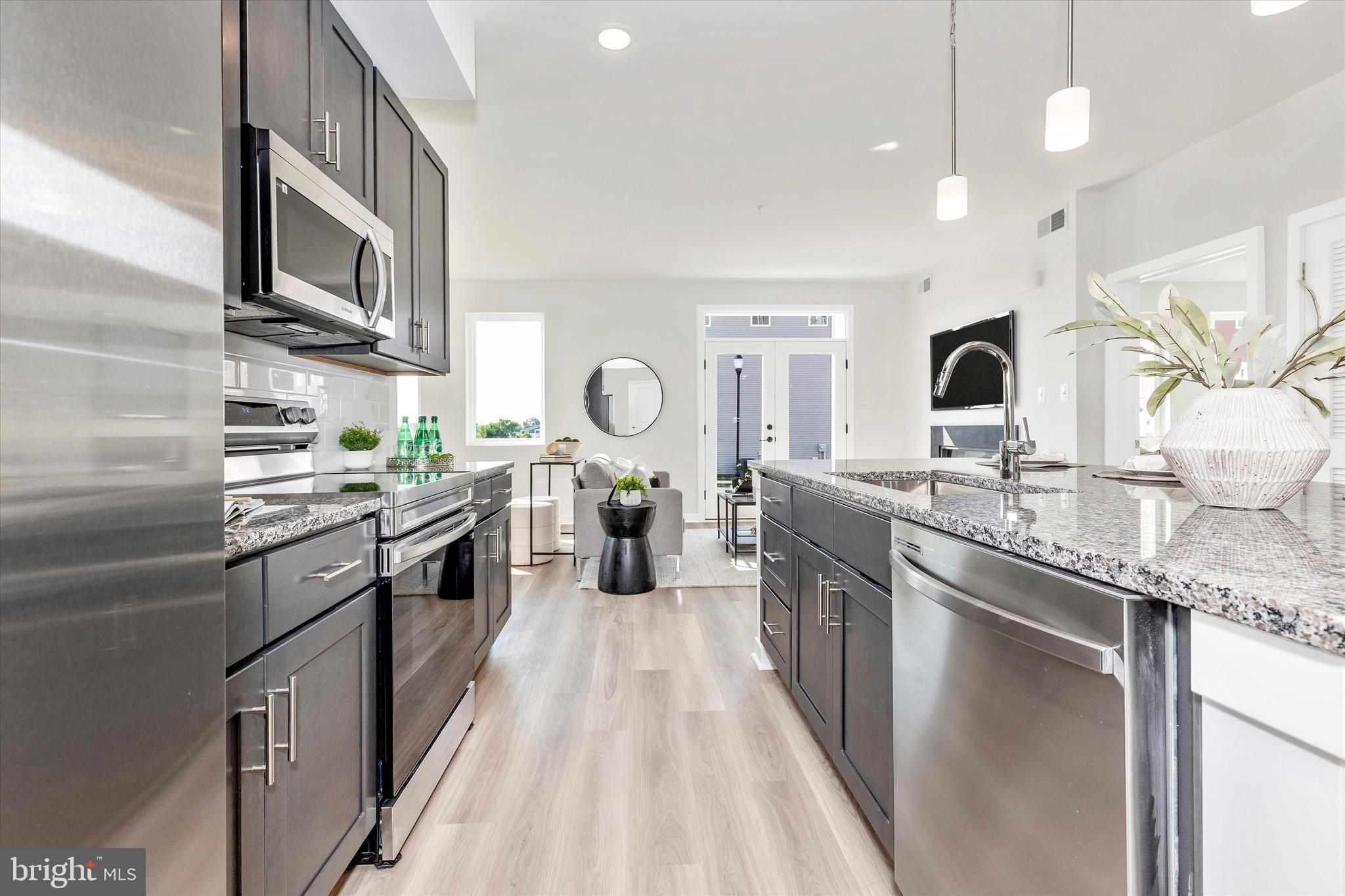 714 Iron Frg Road Frederick, MD 21702 - Photo 17 of 36 a kitchen with stainless steel appliances granite countertop a sink a stove top oven a refrigerator with wooden floors