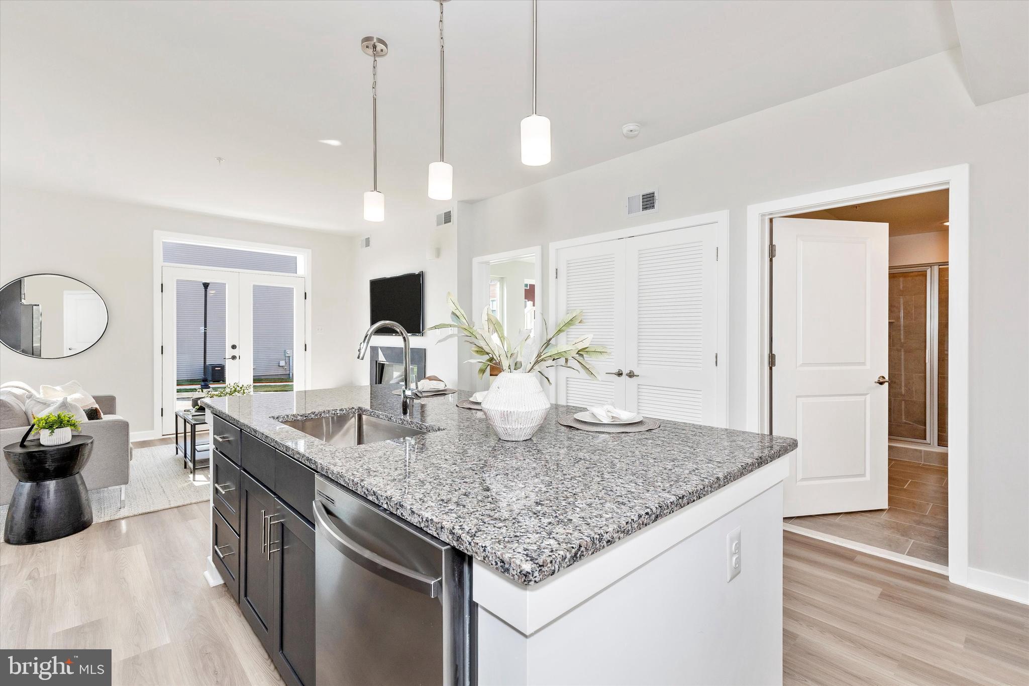714 Iron Frg Road Frederick, MD 21702 - Photo 18 of 36 a kitchen with kitchen island granite countertop a sink cabinets and wooden floor
