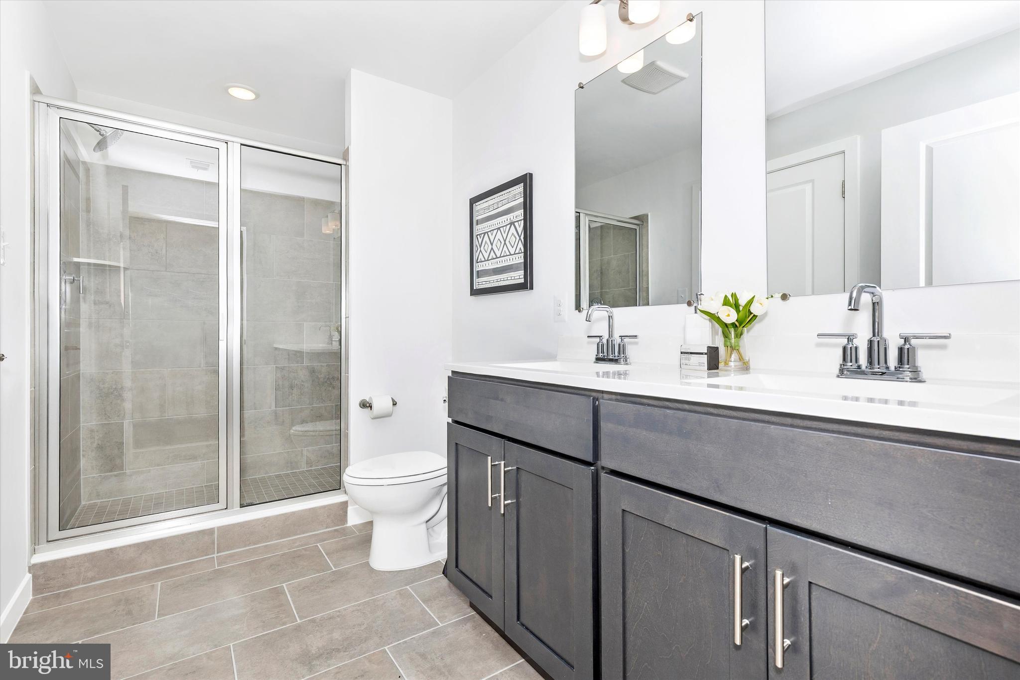 714 Iron Frg Road Frederick, MD 21702 - Photo 23 of 36 a bathroom with a double vanity sink toilet and shower