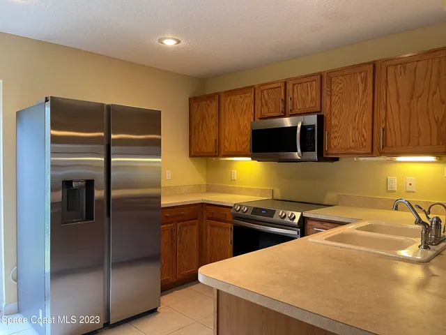 a kitchen with a sink a counter top space cabinets and stainless steel appliances