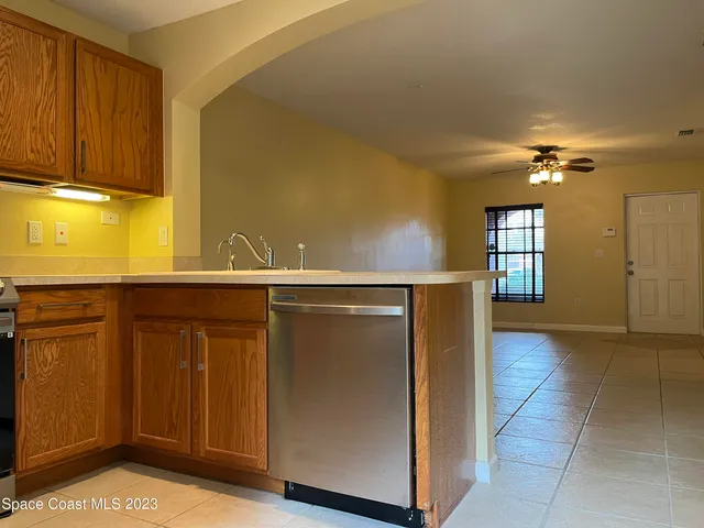 a view of an empty room with a chandelier fan