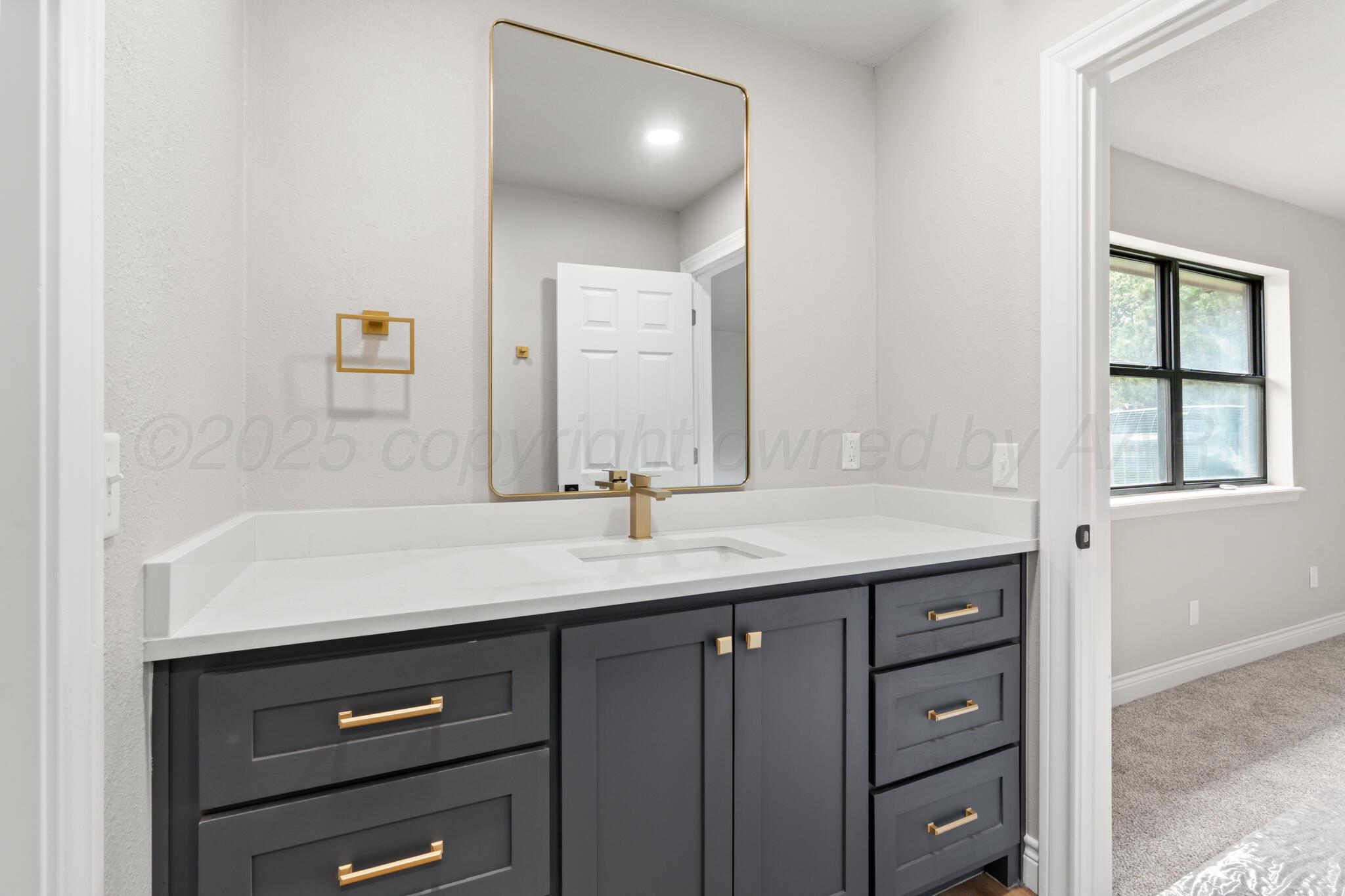 3513 Timber Drive Amarillo, TX 79121 - Photo 16 of 23 a bathroom with a granite countertop sink and a mirror
