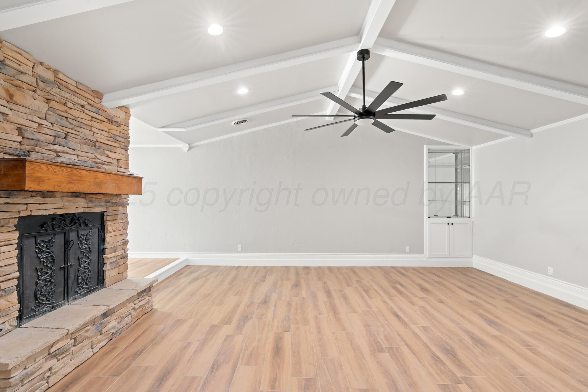 3513 Timber Drive Amarillo, TX 79121 - Photo 3 of 23 a view of an empty room with chandelier fan and wooden floor