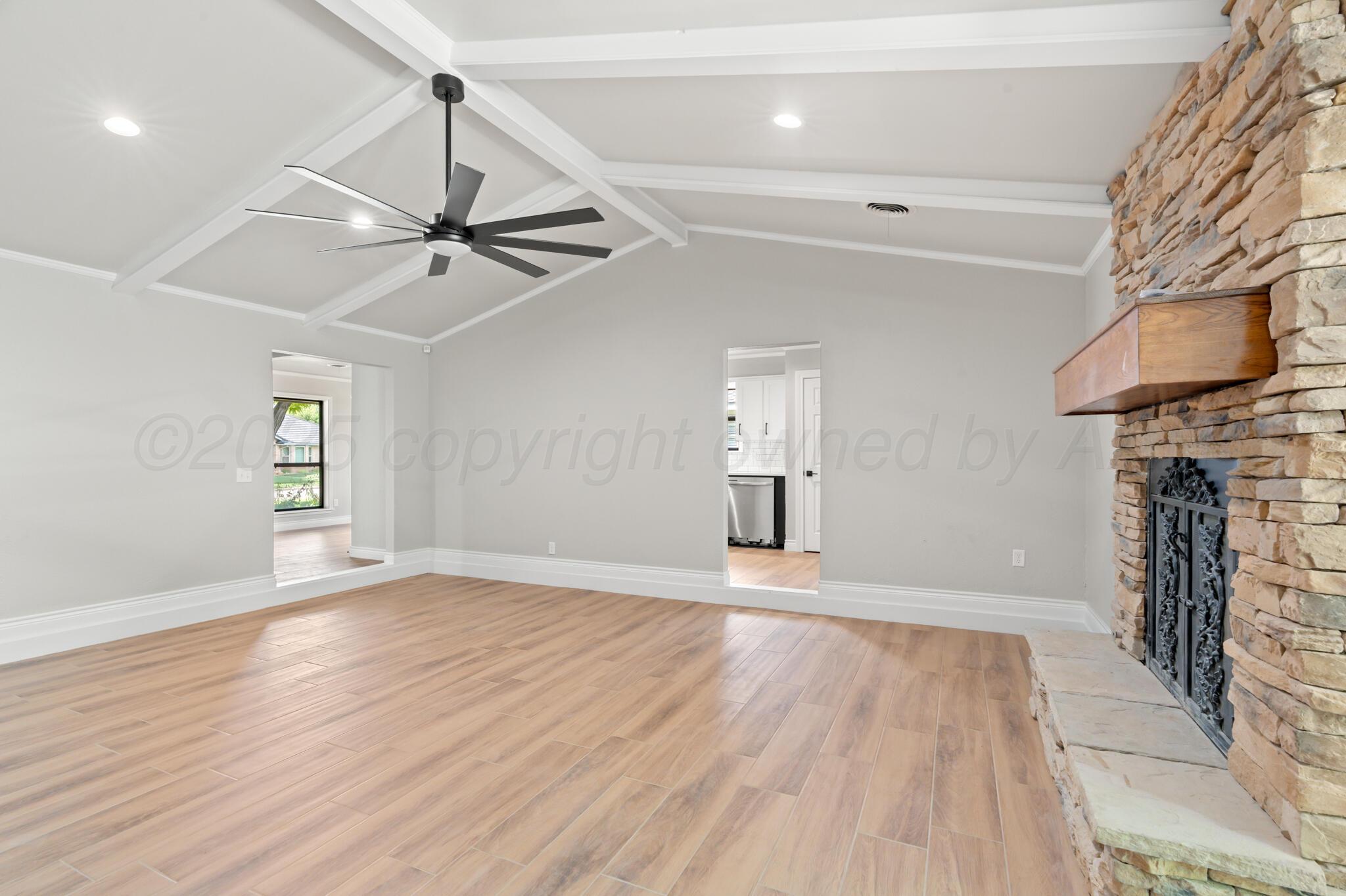 3513 Timber Drive Amarillo, TX 79121 - Photo 4 of 23 a view of an empty room with wooden floor fireplace and a window