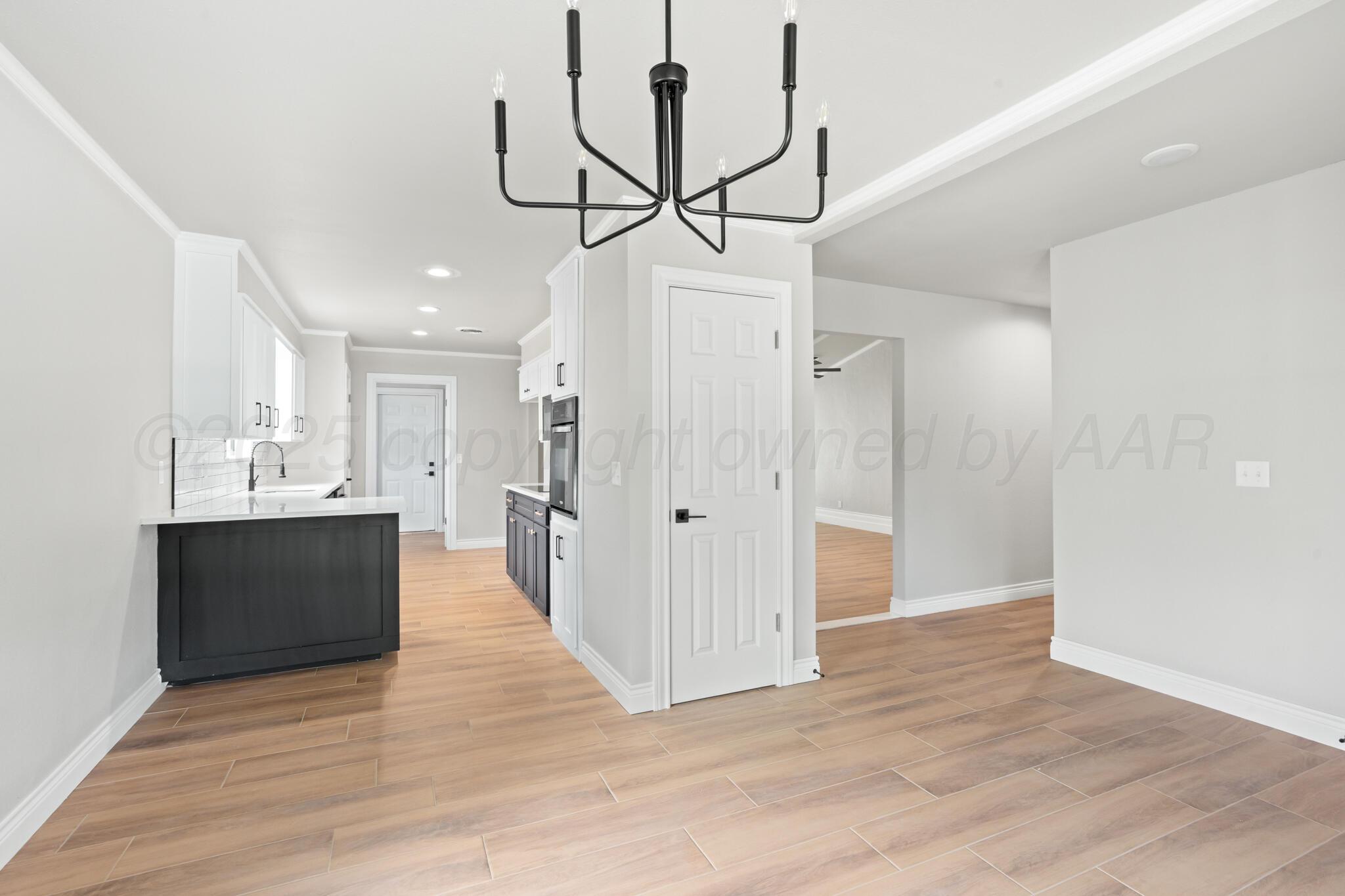 3513 Timber Drive Amarillo, TX 79121 - Photo 9 of 23 a view of a kitchen with wooden floor and a chandelier