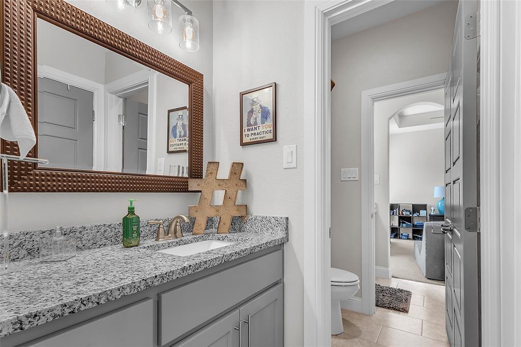 1014 Rennard Street Caddo Mills, TX 75135 - Photo 23 of 39 Jack & Jill Bathroom featuring a linen closet, glass-enclosed shower, granite countertop, framed mirror, brushed nickel finishes and tile flooring