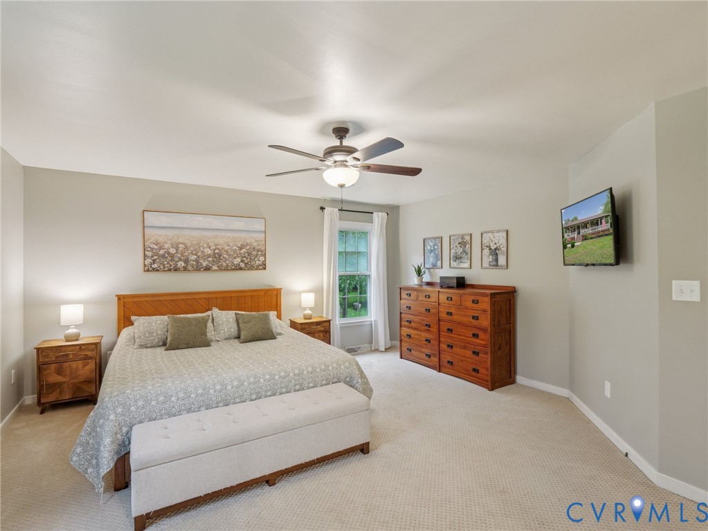 2568 Crewsville Road Bumpass, VA 23024 - Photo 17 of 30 a bedroom with a large bed and a chandelier