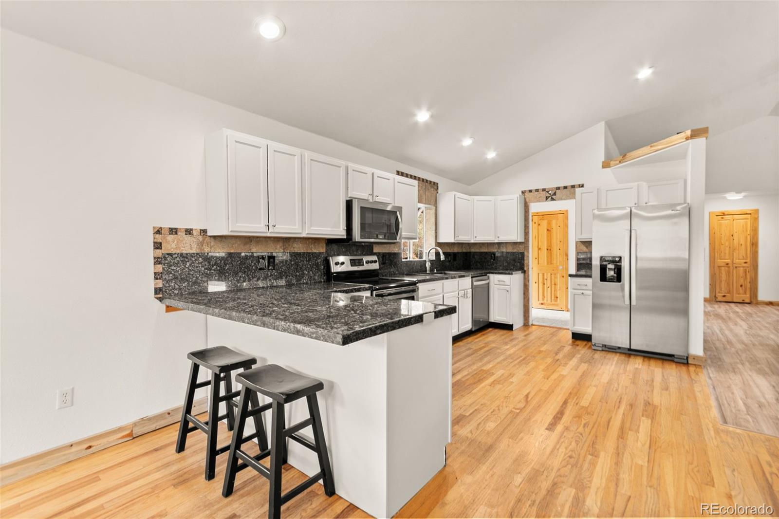 202 Badger Lane Bailey, CO 80421 - Photo 10 of 50 a kitchen with stainless steel appliances granite countertop a refrigerator a stove top oven a sink and dishwasher