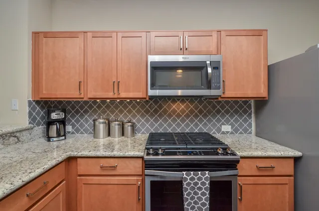 a kitchen with granite countertop a stove top oven cabinetry a sink and dishwasher