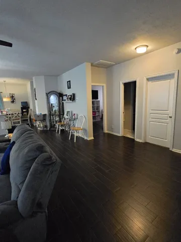 a living room with furniture and a wooden floor