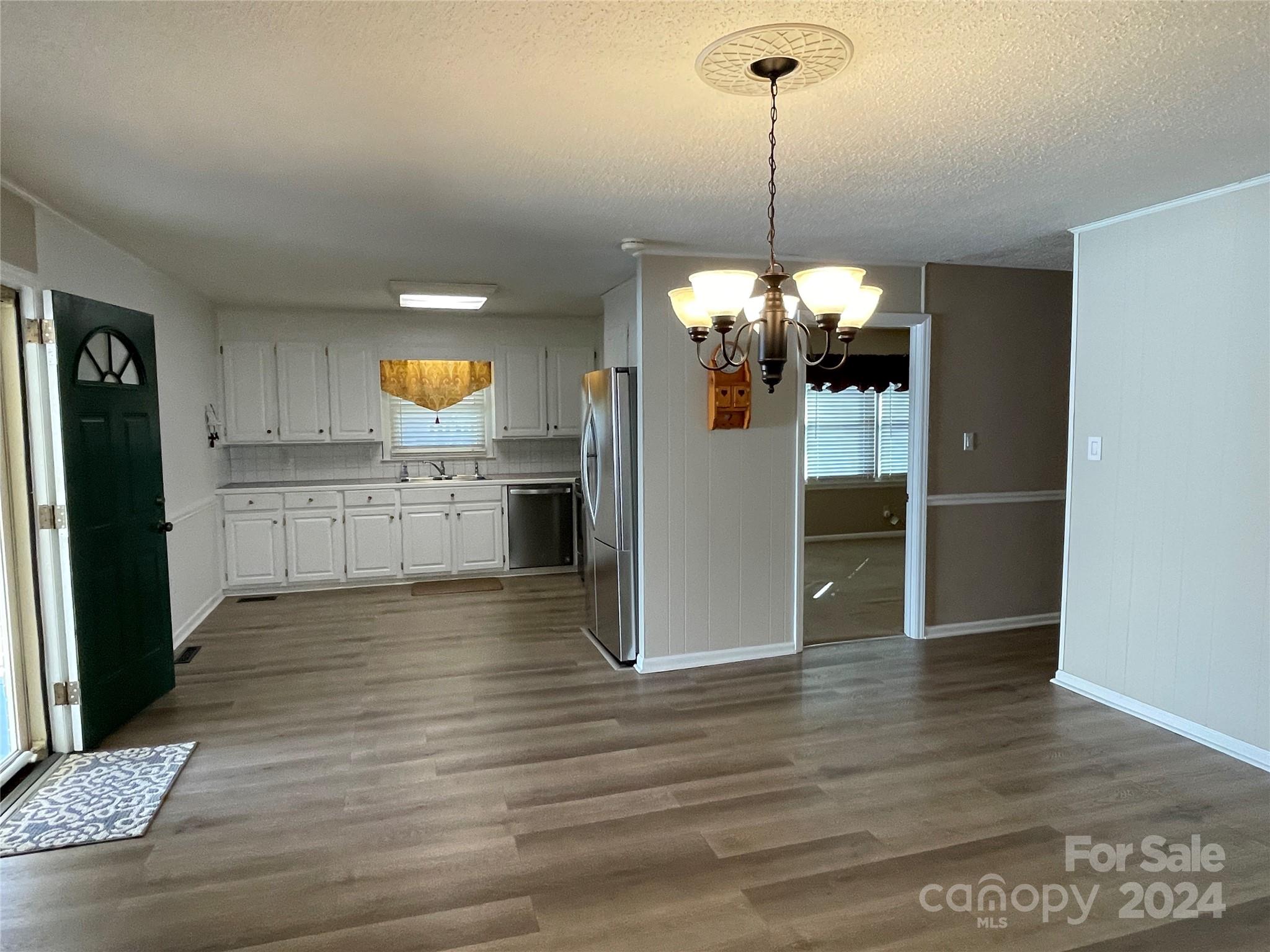 228 Shadowbrook Road Stanley, NC 28164 - Photo 12 of 44 a view of a kitchen with wooden floor and a chandelier