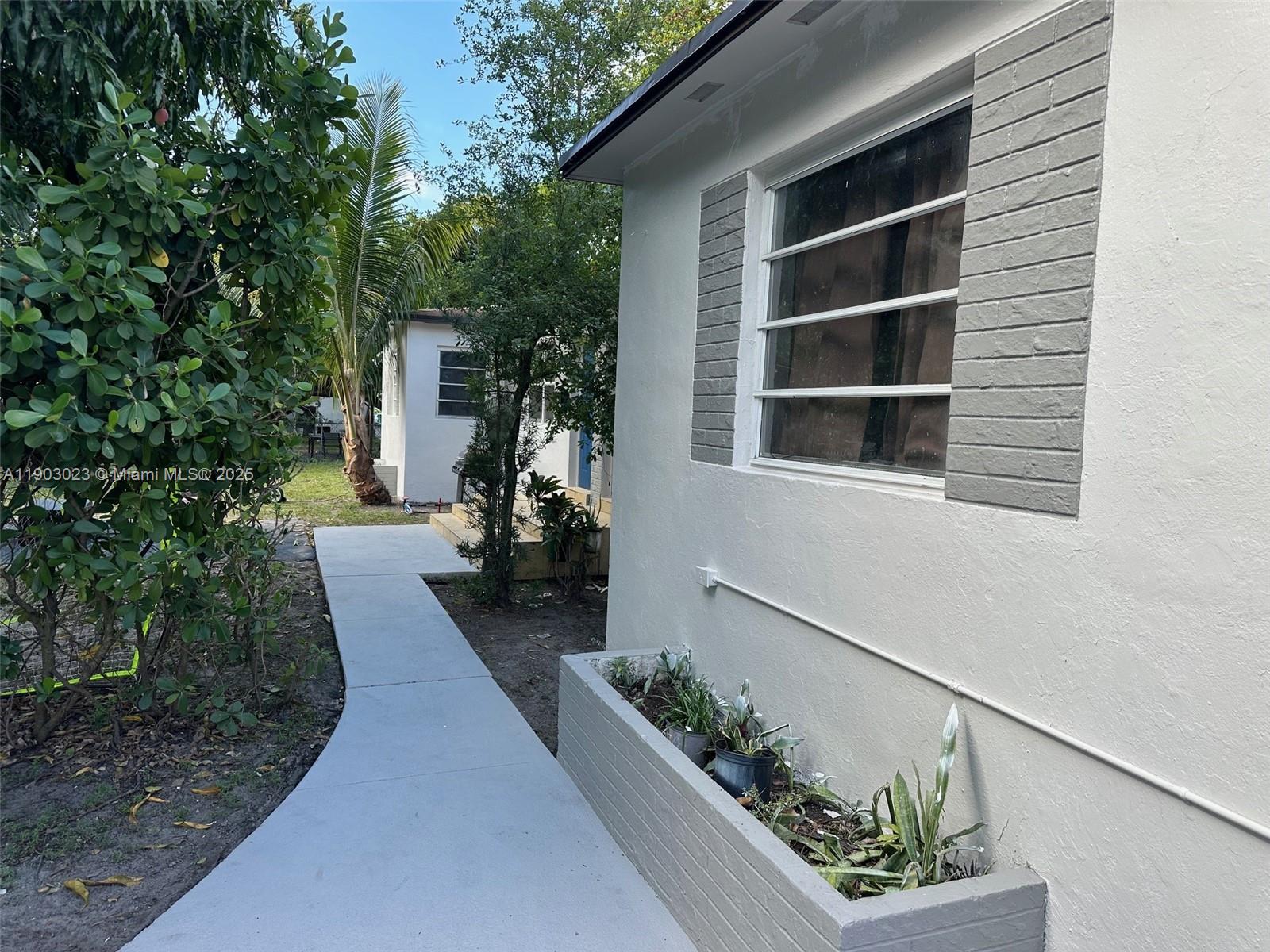 1250 Northwest 58th Street, Unit 1 Miami, FL 33142 - Photo 4 of 10 a front view of a house with a yard