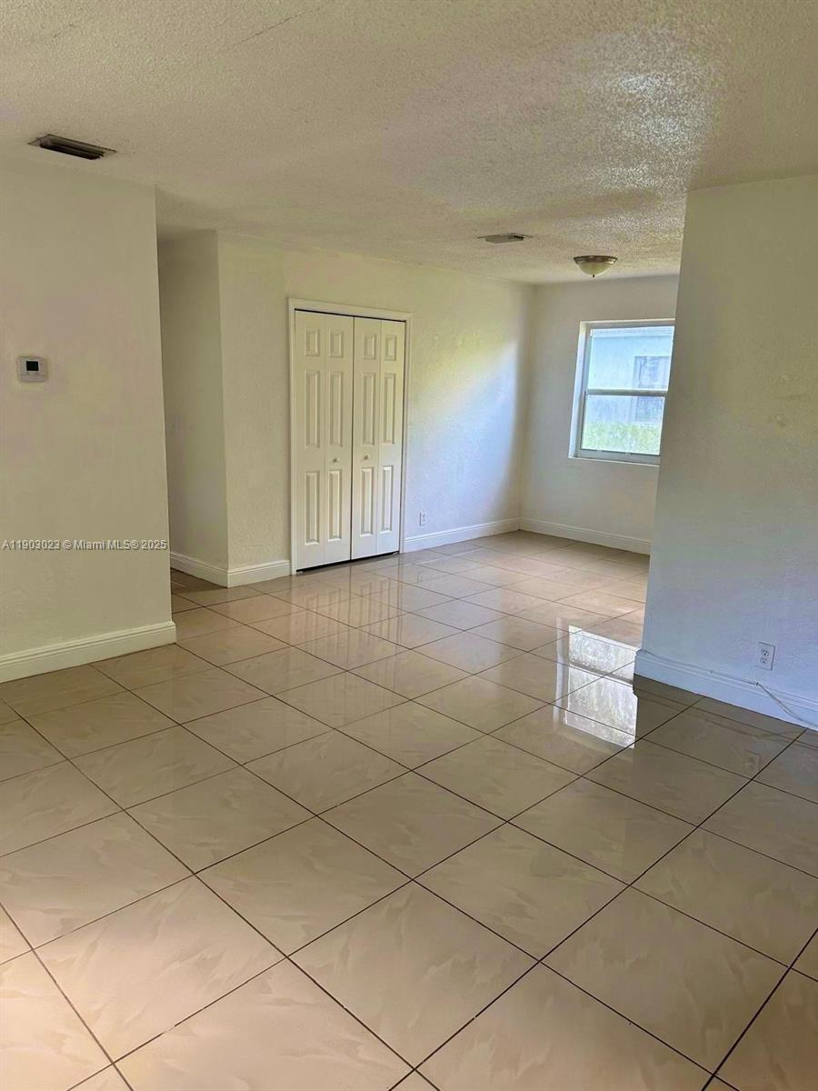1250 Northwest 58th Street, Unit 1 Miami, FL 33142 - Photo 6 of 10 a view of an empty room and window