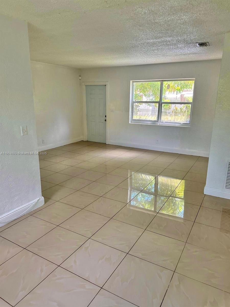1250 Northwest 58th Street, Unit 1 Miami, FL 33142 - Photo 7 of 10 an empty room with windows