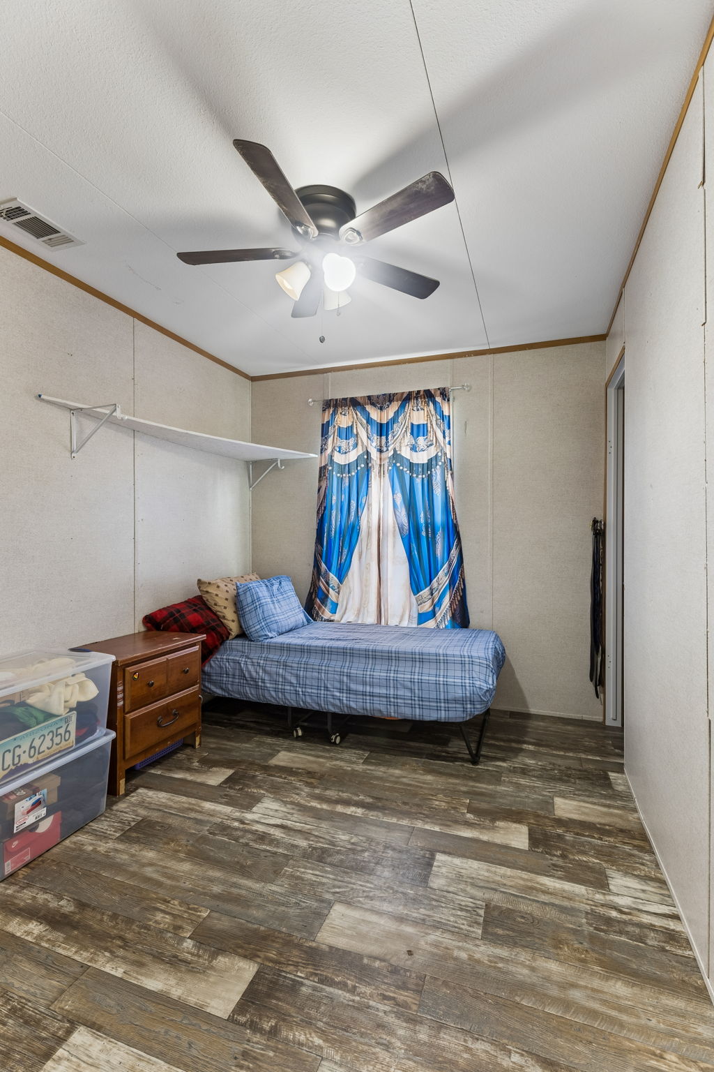 253 North County Line Road, Unit C Elgin, TX 78621 - Photo 17 of 39 Well-lit room with wood plank flooring and a functional ceiling fan.