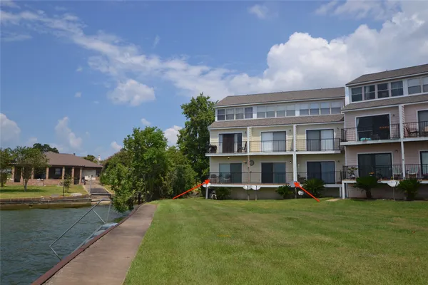 a view of an apartment with a garden and trees