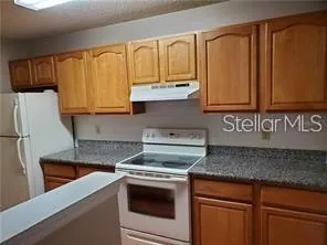 a kitchen with granite countertop cabinets stainless steel appliances and a sink