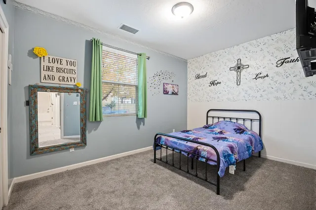 a bedroom with a bed and a tv on the wall