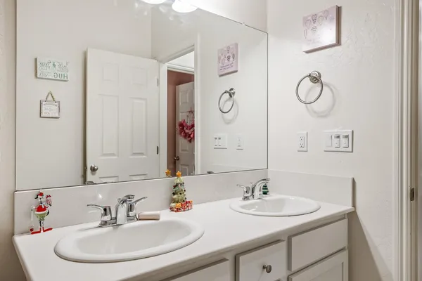 a bathroom with double vanity sinks and a mirror