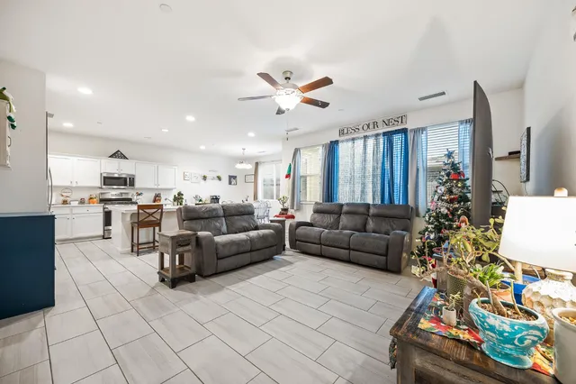 a living room with furniture and a dining table with kitchen view