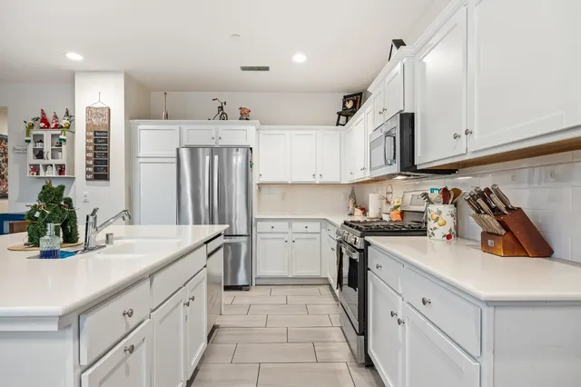 a kitchen that has a lot of cabinets in it and wooden floors