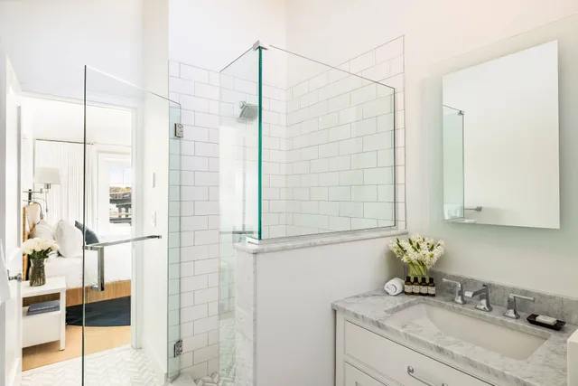 a bathroom with a granite countertop sink a mirror and shower
