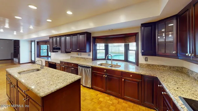 a kitchen with stainless steel appliances a refrigerator a oven a sink with granite countertops and cabinets
