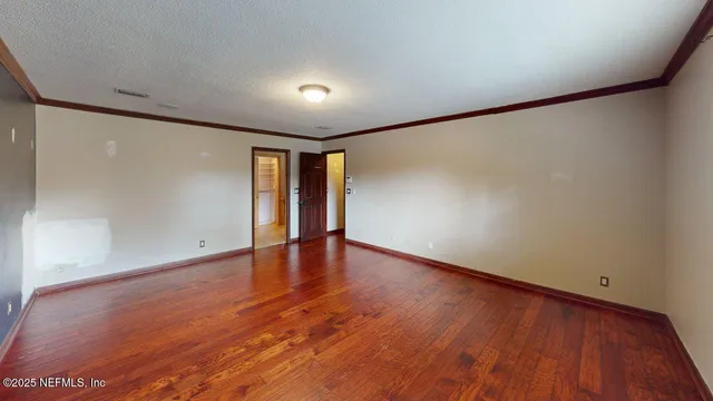 a room with walk in closet and wooden floor