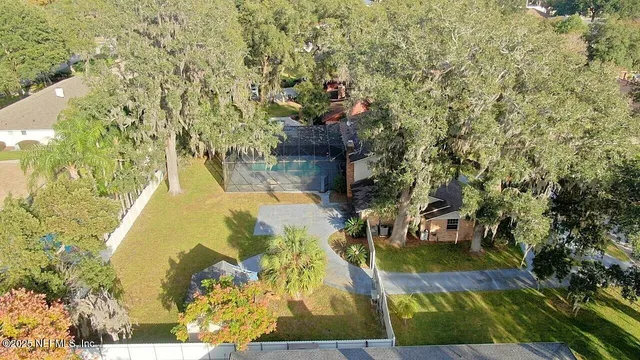 an aerial view of a house with outdoor space and swimming pool