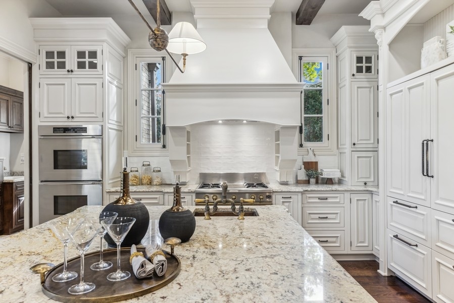 927 Cleveland Road Hinsdale, IL 60521 - Photo 13 of 46 a kitchen with stainless steel appliances kitchen island granite countertop a refrigerator a stove and white cabinets with wooden floors