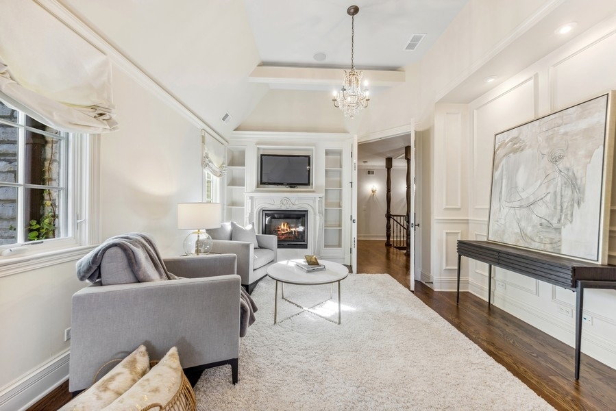 927 Cleveland Road Hinsdale, IL 60521 - Photo 24 of 46 a living room with furniture a chandelier and a fireplace