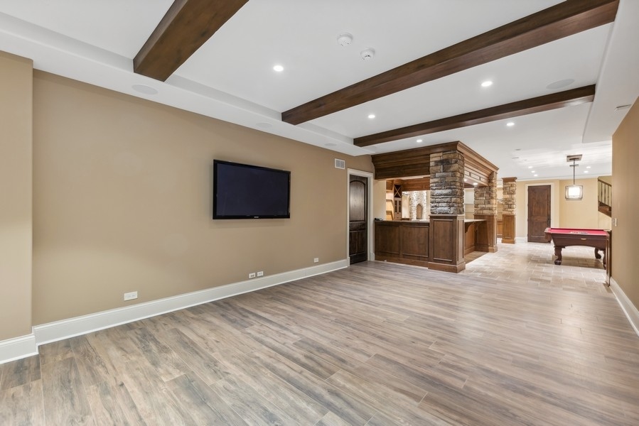927 Cleveland Road Hinsdale, IL 60521 - Photo 33 of 46 an empty room with wooden floor and kitchen view