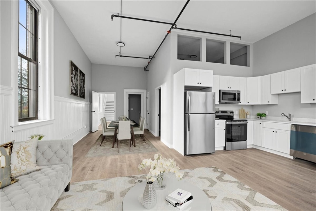 22 Waverly Street Worcester, MA 01604 - Photo 15 of 41 a kitchen with stainless steel appliances kitchen island granite countertop a refrigerator a stove top oven a sink dishwasher and white cabinets with wooden floor