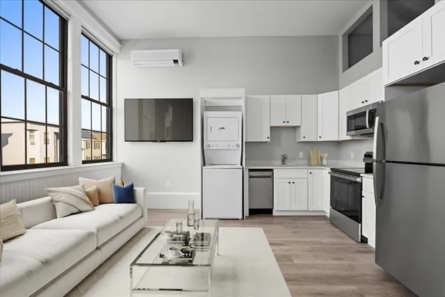 a living room with furniture wooden floor and large window