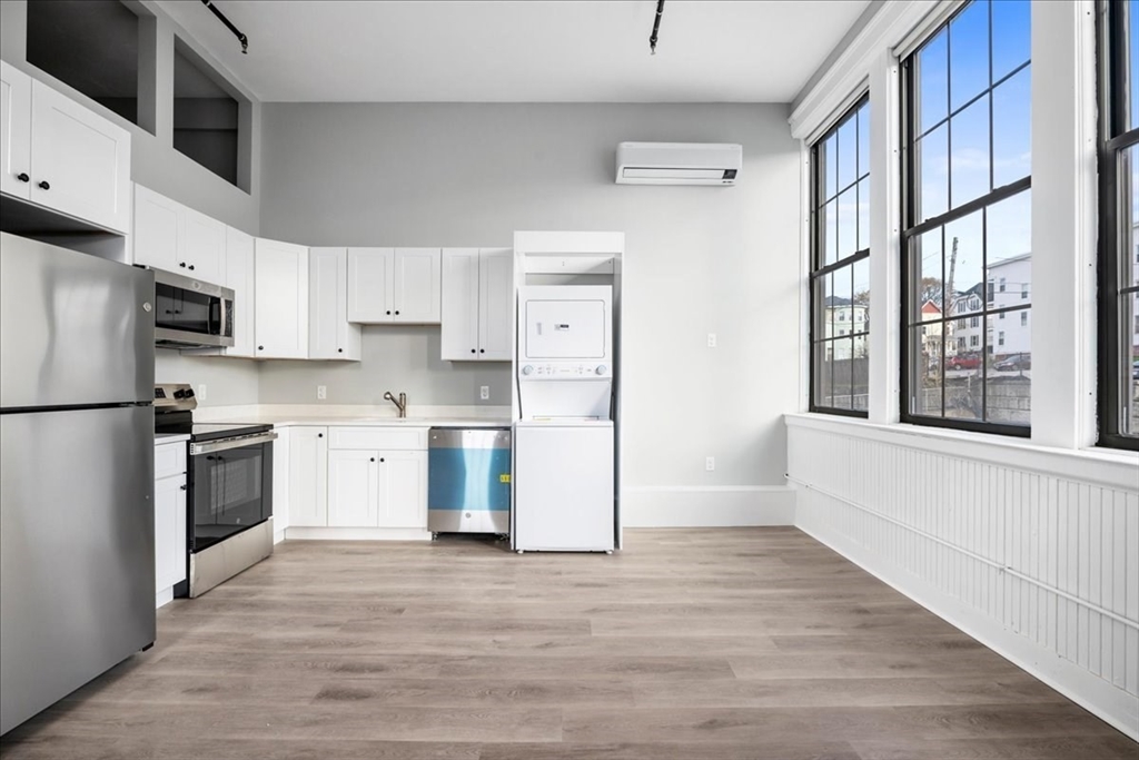 22 Waverly Street Worcester, MA 01604 - Photo 4 of 41 a kitchen with granite countertop a refrigerator a sink dishwasher and a stove with wooden floors